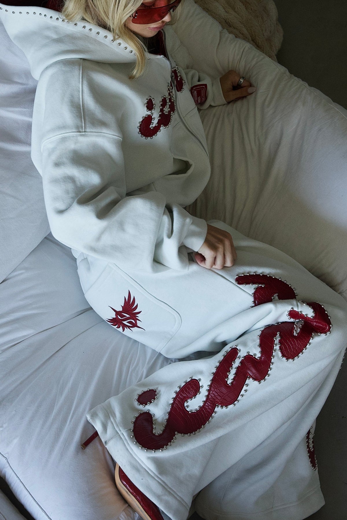 Pantaloni della tuta rossi con borchie effetto coccodrillo
