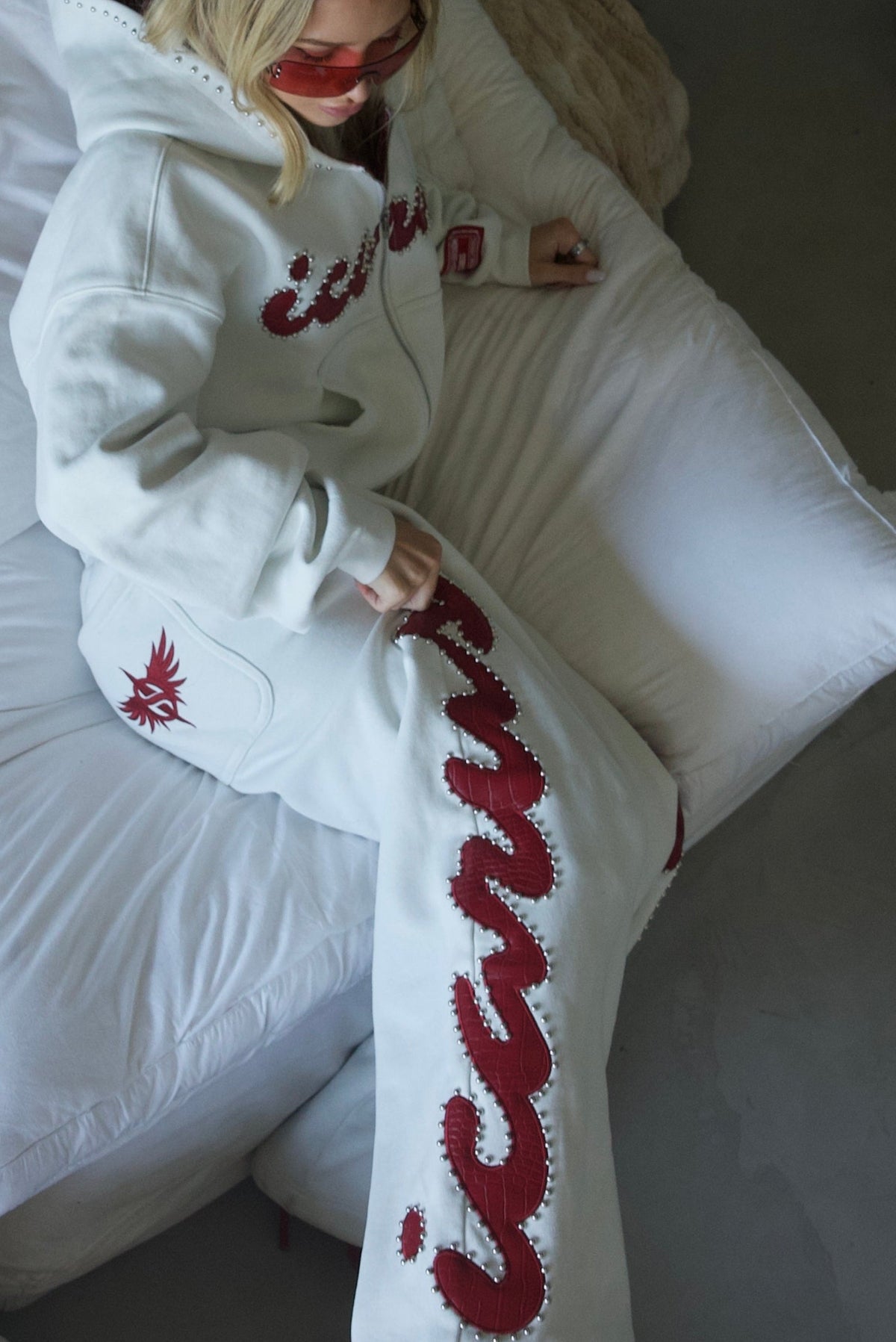 Pantaloni della tuta rossi con borchie effetto coccodrillo
