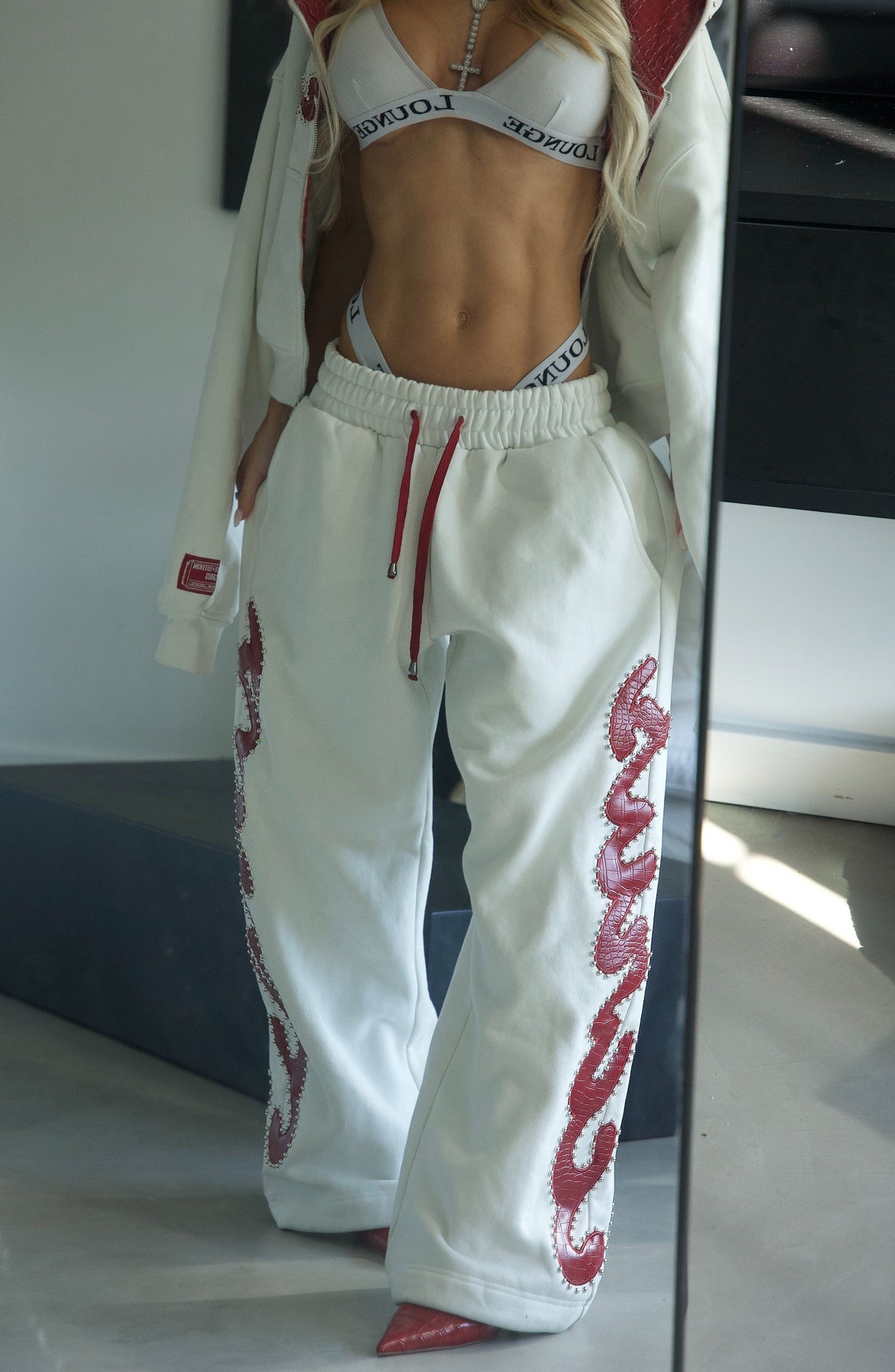 Pantaloni della tuta rossi con borchie effetto coccodrillo
