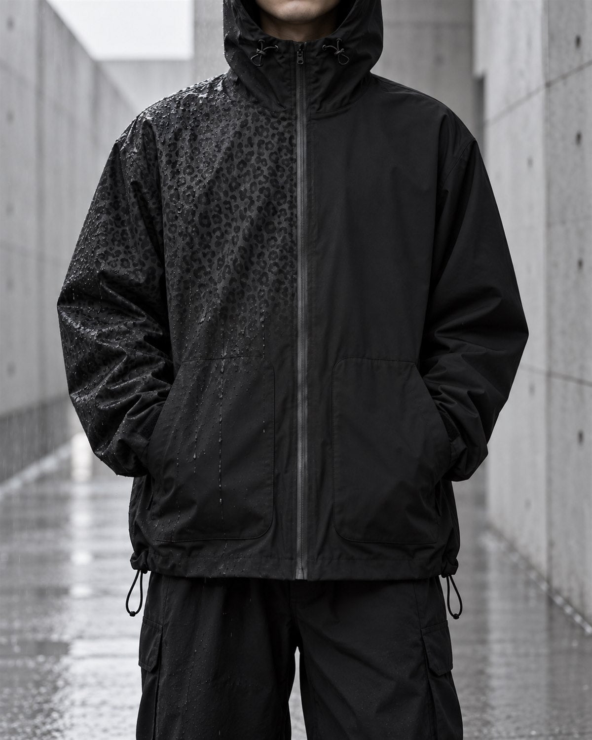Unisex black water-reactive jacket showing wet patterned and dry matte sides